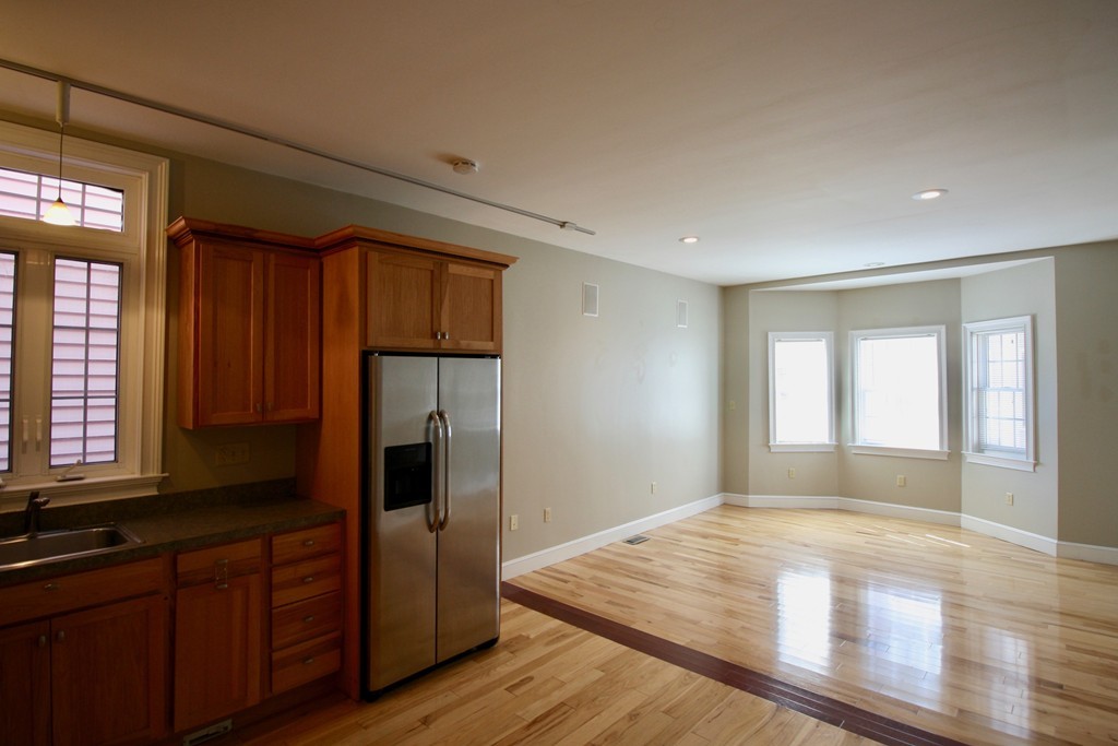 a view of kitchen with wooden floor and electronic appliances