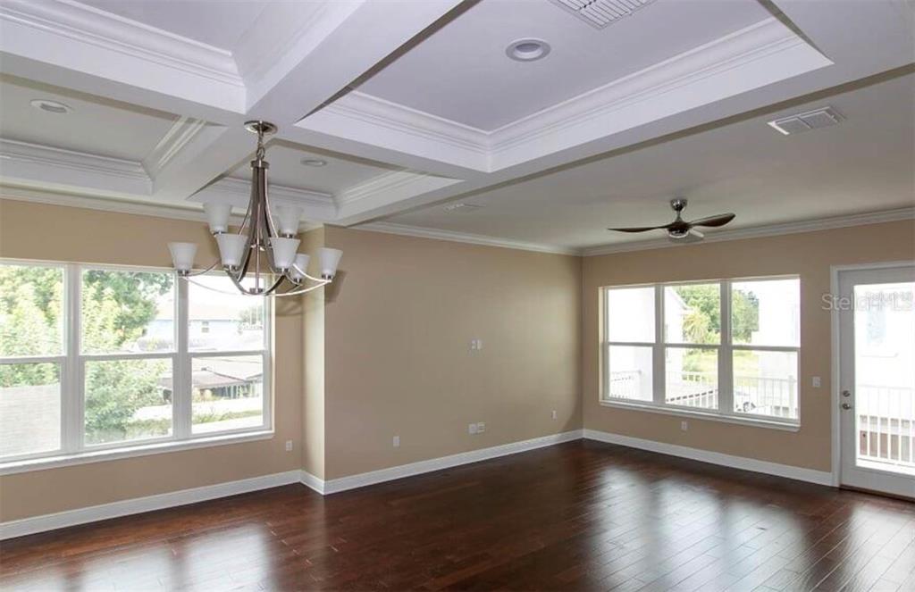 3702 West Roland Street, Unit 13 Tampa, FL 33609 - Photo 4 of 10 a view of an empty room with wooden floor and a window