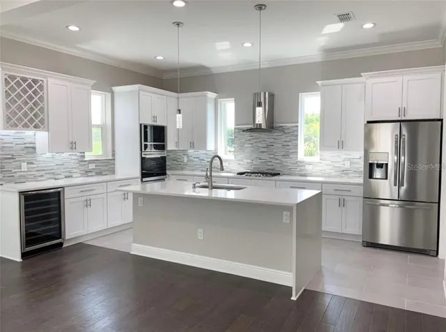 a kitchen with a refrigerator and a stove top oven