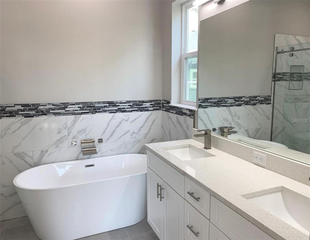 3702 West Roland Street, Unit 13 Tampa, FL 33609 - Photo 8 of 10 a bathroom with a bathtub and a sink