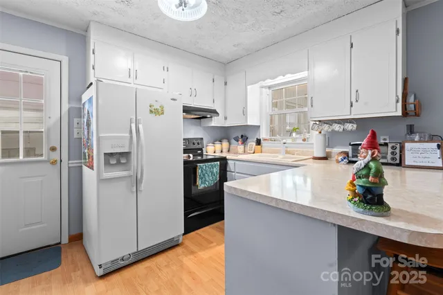 a kitchen with stainless steel appliances granite countertop a sink a stove and a window