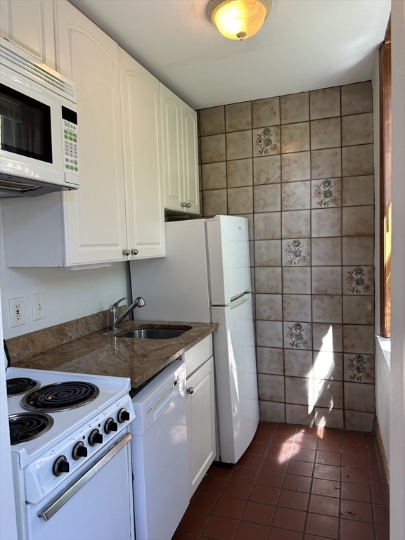 17 South Russell Street, Unit 8 Boston, MA 02114 - Photo 4 of 11 a kitchen with granite countertop a sink a stove a refrigerator and cabinets