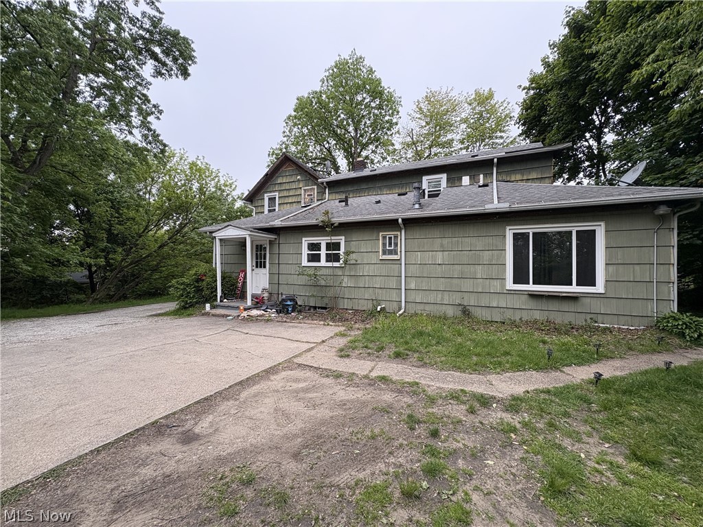 727 Wooster Road North Barberton, OH 44203 - Photo 6 of 37 Green shingle-sided exterior featuring white trim, a covered entry porch, and multiple windows