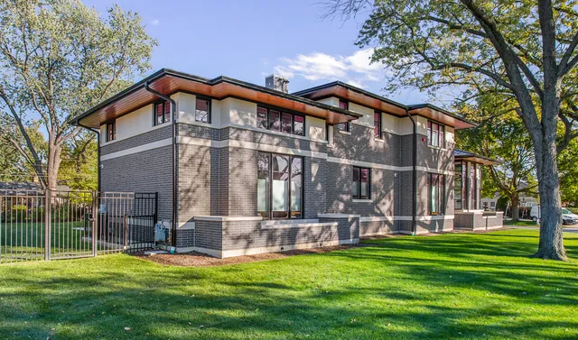a view of a blue house with large windows and a garage