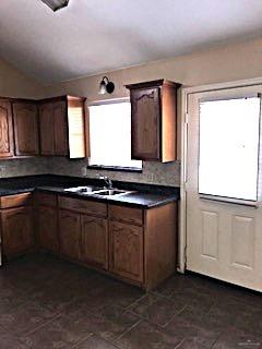 2213 West Candlelight Lane, Unit 4 Edinburg, TX 78541 - Photo 5 of 15 Kitchen featuring dark countertops and lofted ceiling