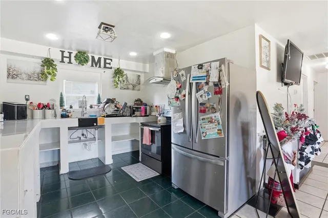 a kitchen with stainless steel appliances granite countertop a refrigerator and a sink