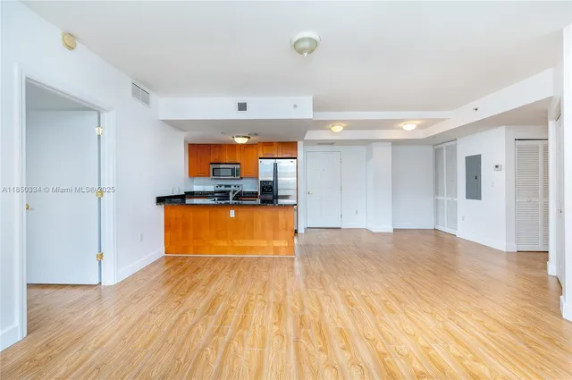 a view of a kitchen with wooden floor and a sink