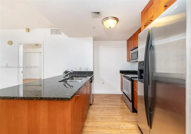 a kitchen with stainless steel appliances granite countertop a stove and a refrigerator