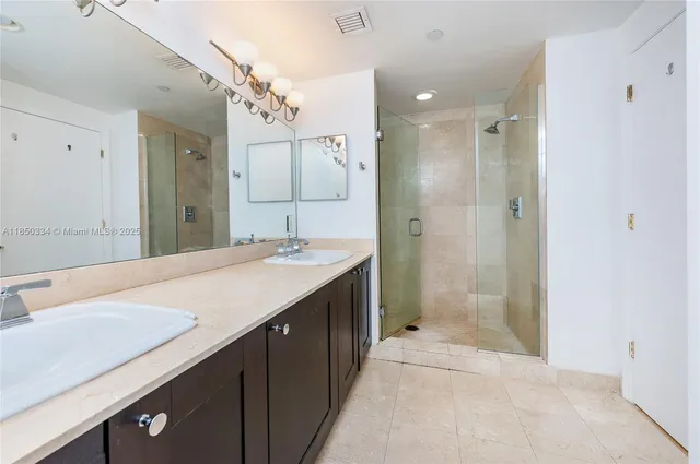 a bathroom with a sink a shower a mirror and a bathtub