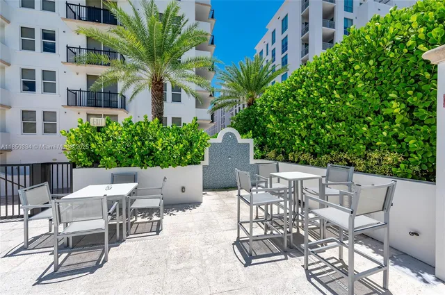 a view of a patio with a table and chairs and potted plants