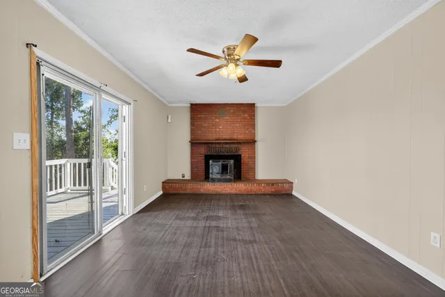 a view of an empty room with window and wooden floor