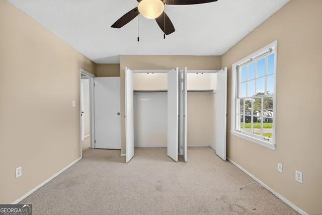 an empty room with windows and closet