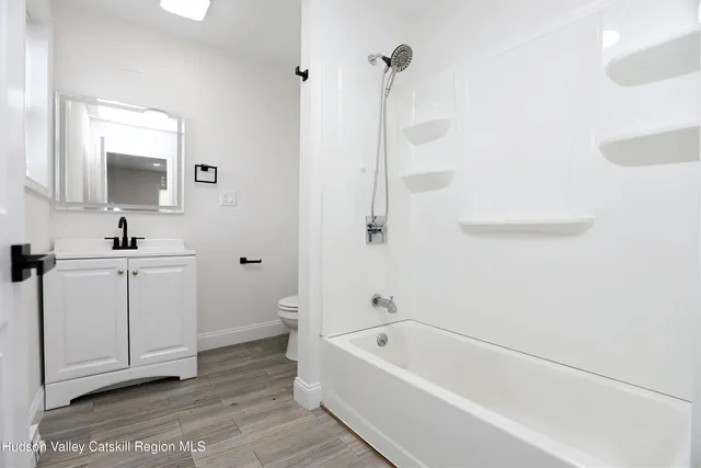 a bathroom with a bathtub a mirror a sink and vanity