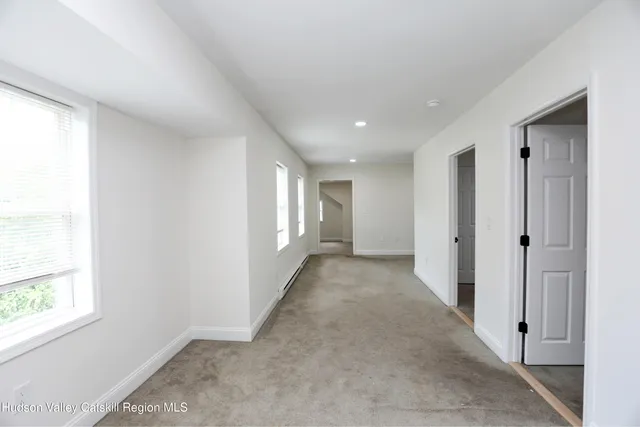 a view of hallway with windows and closet