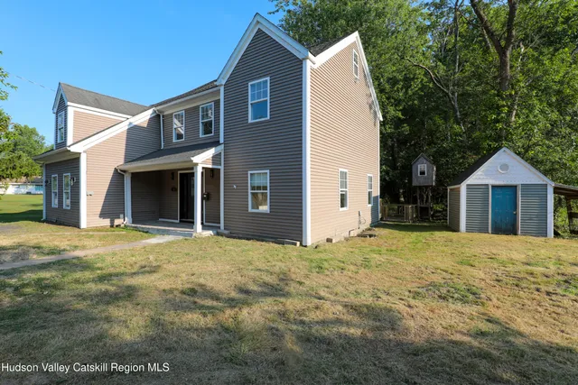 a view of a house with a yard and wooden fence