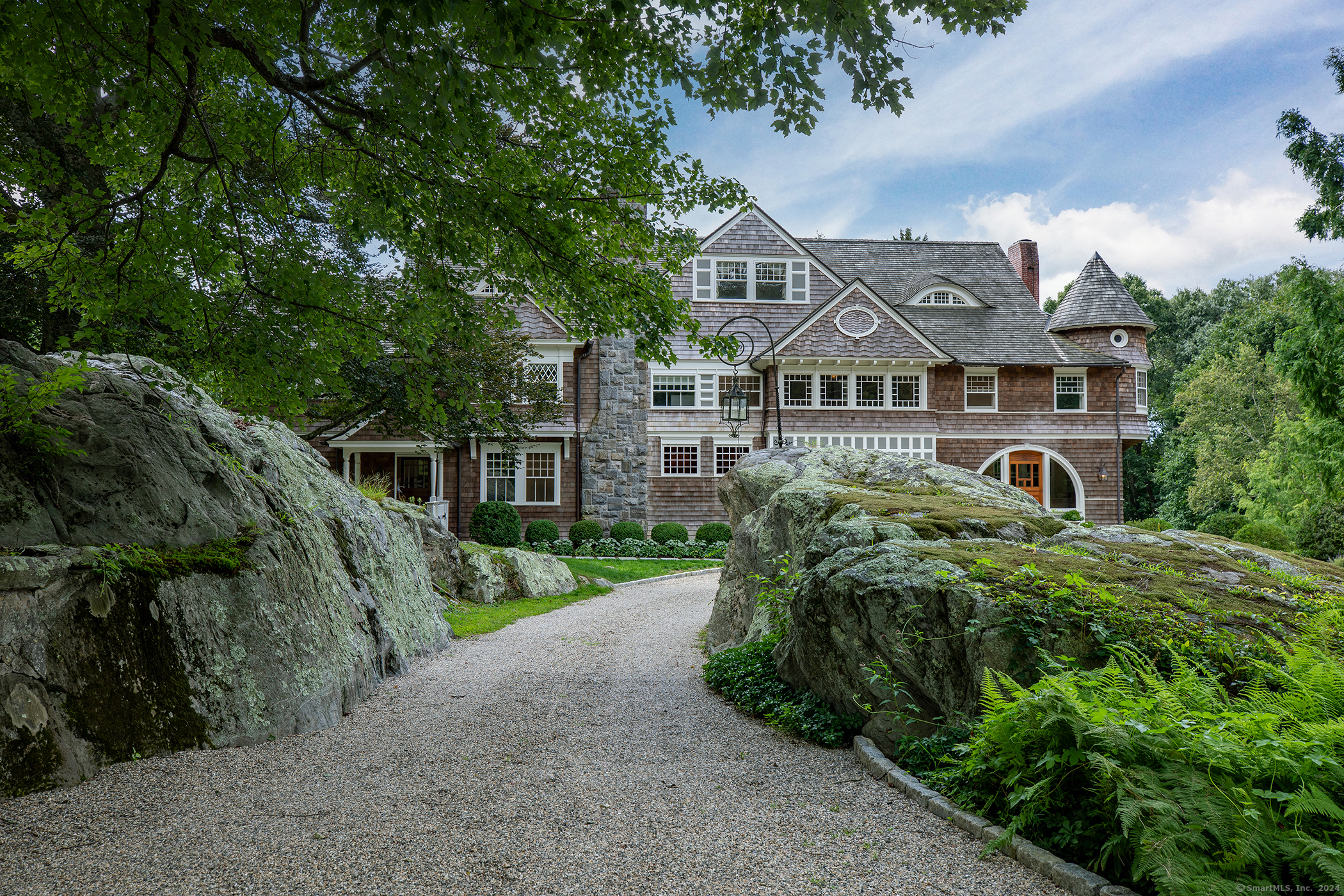 a front view of a house with a yard and potted plants