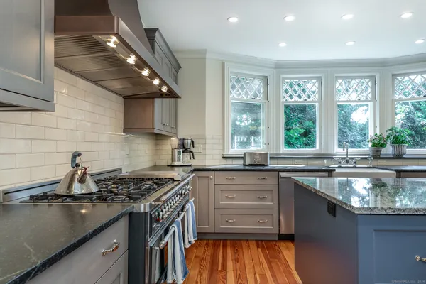 a kitchen with a sink stove top oven and cabinets