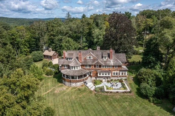 an aerial view of a house with swimming pool and garden