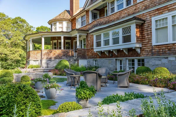 a view of a patio with couches table and chairs potted plants and large tree