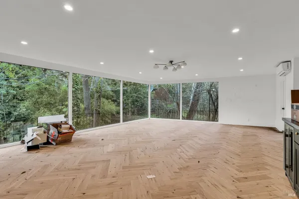 a view of an empty room with furniture and a flat screen tv