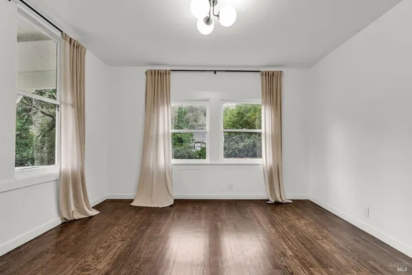 an empty room with wooden floor and window