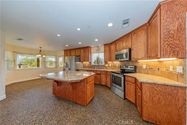 an empty room with wooden floor chandelier fan and windows