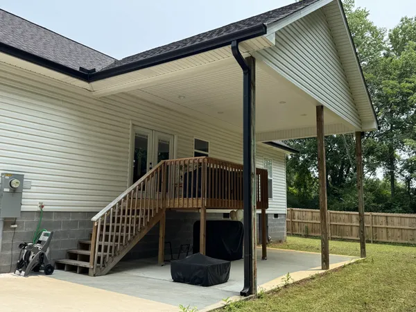 a view of a house with backyard and deck
