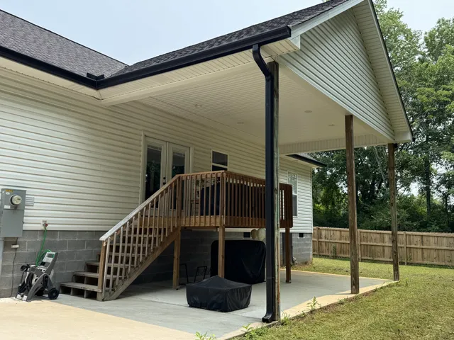 a view of a house with backyard and deck
