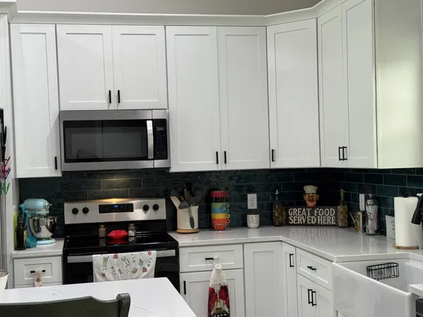 a kitchen with stainless steel appliances granite countertop a stove and a microwave