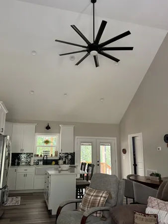 a kitchen with a refrigerator a stove a sink dishwasher a dining table and chairs with wooden floor