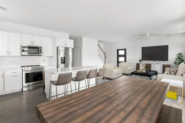 a kitchen with a table chairs refrigerator and window