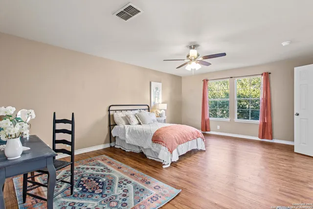 a spacious bedroom with a bed a table and a chandelier