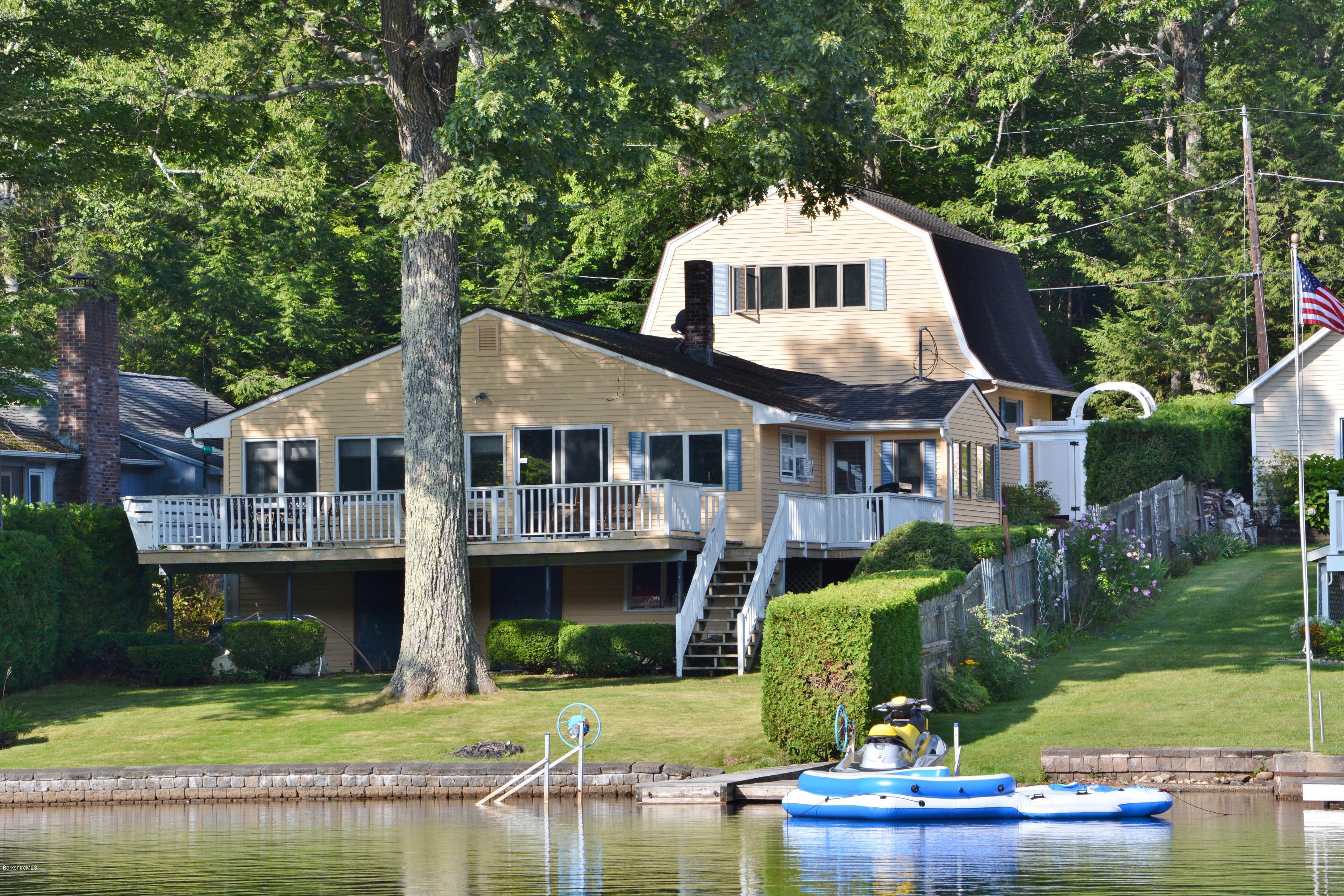 77 North Gate Island Road Otis, MA 01029 - Photo 1 of 25 a front view of a house with a yard table and chairs