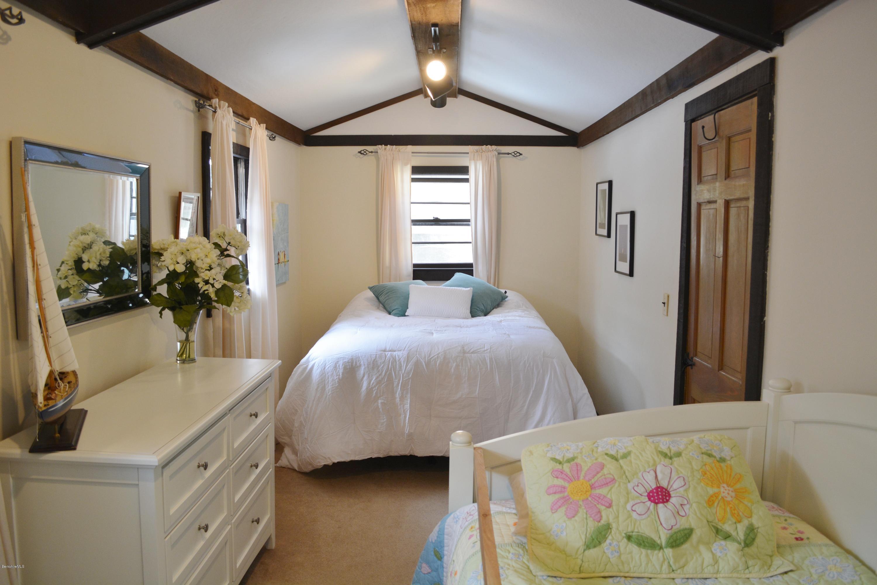 77 North Gate Island Road Otis, MA 01029 - Photo 18 of 25 a bedroom with a bed and a chandelier