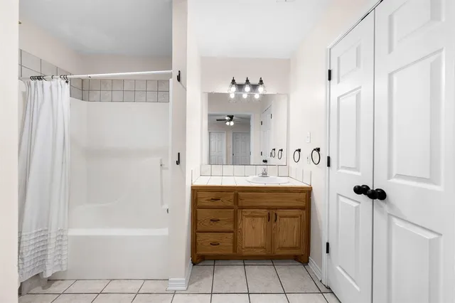 a bathroom with a bathtub sink vanity and mirror