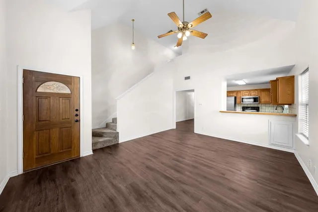 a view of a kitchen with wooden floor and a ceiling fan