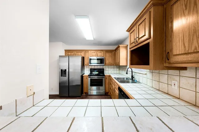 a kitchen with stainless steel appliances a sink and a refrigerator