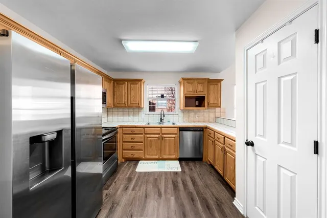a kitchen with stainless steel appliances granite countertop a stove a sink and a refrigerator