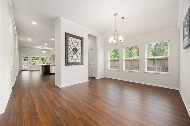 a view of an empty room with window and wooden floor