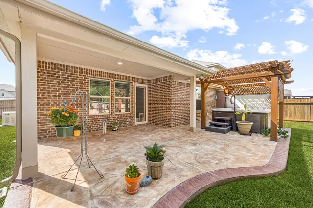 a view of a patio with table and chairs potted plants and floor to ceiling window