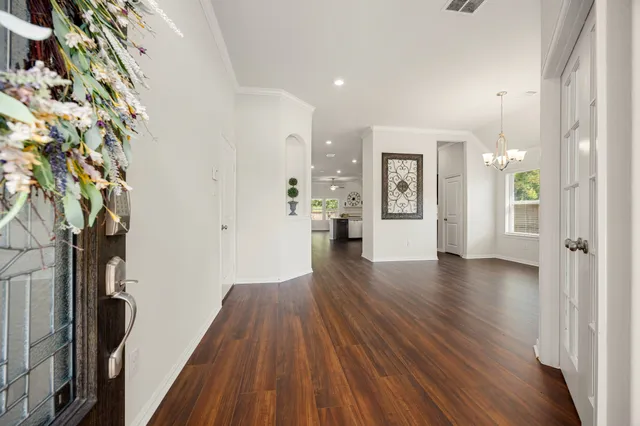 a view of a hallway with wooden floor and windows