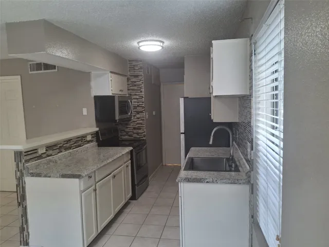 a kitchen with sink cabinets and stove