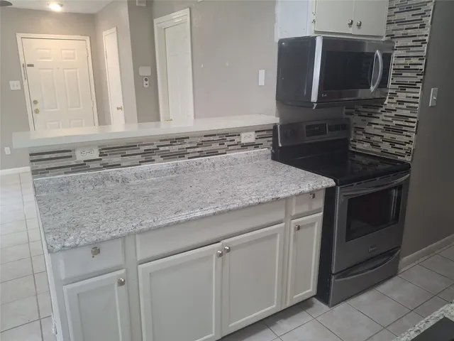 a kitchen with granite countertop a sink and stainless steel appliances