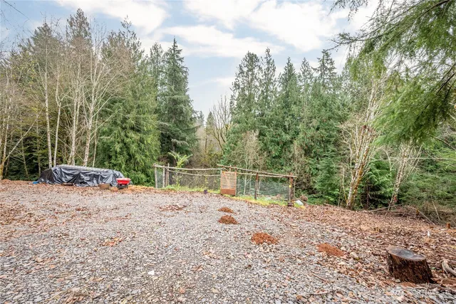 a view of a lake with beach and trees around