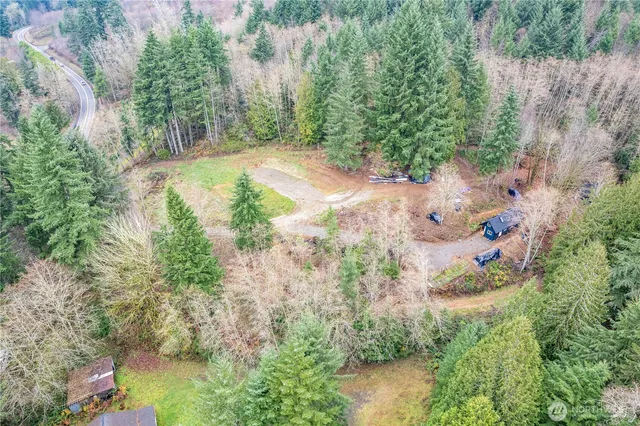a view of a house with a lush green forest