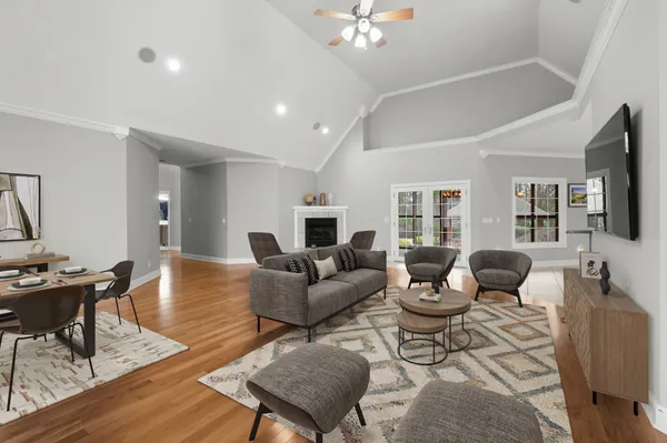 a living room with furniture a flat screen tv and kitchen view