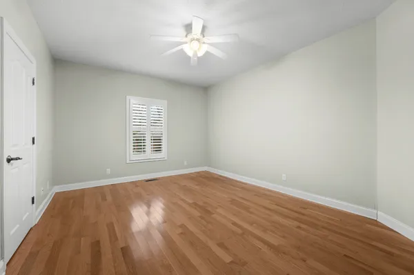 a view of an empty room with a chandelier fan