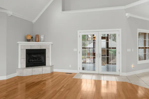 a view of a room with wooden floor chandelier and windows