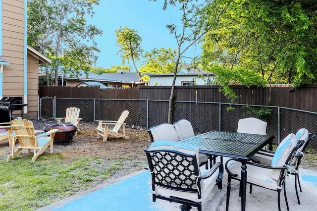 a backyard of a house with table and chairs