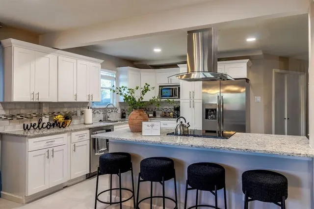 a kitchen with stainless steel appliances a sink and cabinets